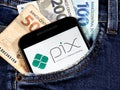 Smartphone with Pix logo on the screen in jeans pocket with notes of 100 reais. Pix is Ã¢â¬â¹Ã¢â¬â¹the Brazilian instant payment.